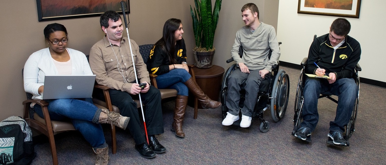 Several people sitting and smiling in the SDS office lobby.