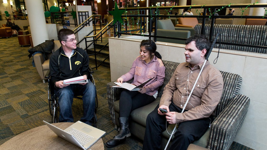Three people sitting and talking in the lobby of the Burge Residence Hall